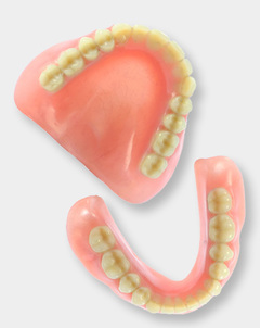 A set of upper and lower dentures laying on a surface